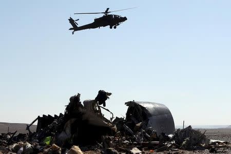 An Egyptian military helicopter flies over debris from a Russian airliner which crashed at the Hassana area in Arish city, north Egypt, November 1, 2015. REUTERS/Mohamed Abd El Ghany