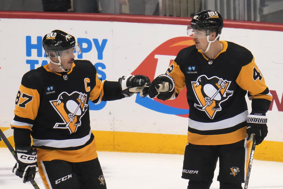 Pittsburgh Penguins' Kasperi Kapanen (42) celebrates with Sidney Crosby (87) after Kapanen scored during the first period of the team's NHL hockey game against the St. Louis Blues in Pittsburgh, Saturday, Dec. 3, 2022. It was Kapanen's second goal of the period. (AP Photo/Gene J. Puskar)