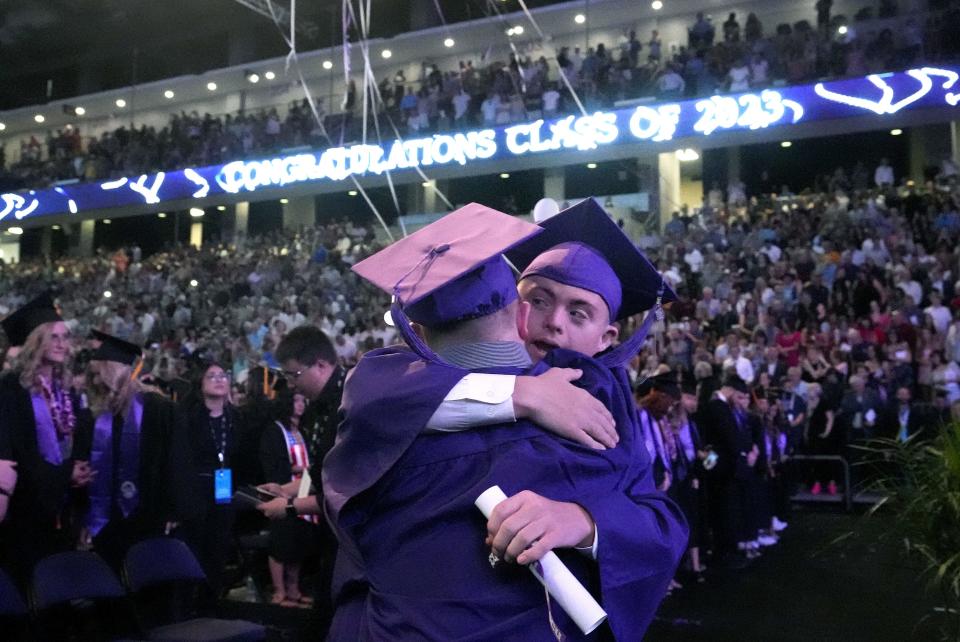 Apr 28, 2023; Phoenix, Ariz., U.S.;  Chase Baird (with back to the camera) and Matthew Adams, participants in the LOPES Academy, a nondegree program for individuals with intellectual and developmental disabilities, hug during Grand Canyon"s 2023 commencement ceremony. Baird and Adams received a completion certificate during the ceremony.