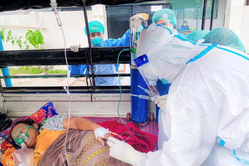 Volunteers help a coronavirus (COVID-19) patient in the town of Kale, Sagaing Region, Myanmar