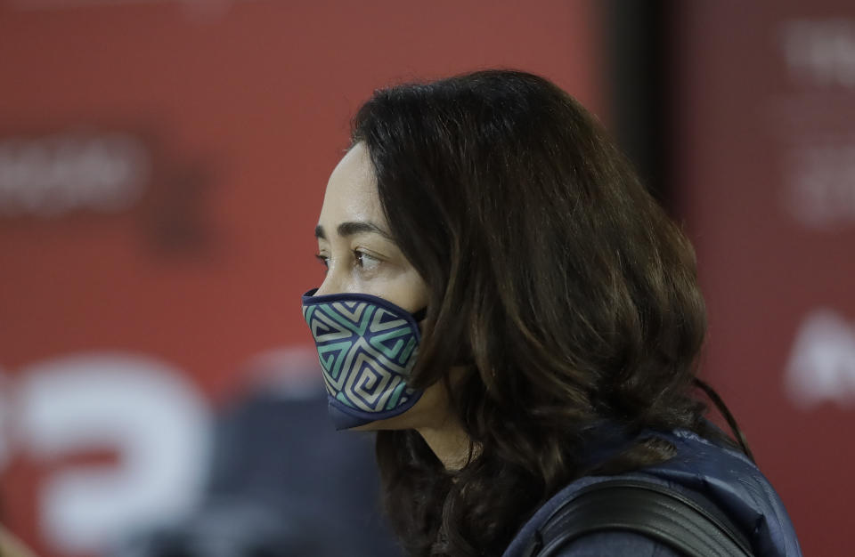 A woman uses a sleep mask over her mouth as a precaution against the spread of the new coronavirus COVID-19 after her flight landed at the Sao Paulo International Airport in Sao Paulo, Brazil, Thursday, Feb. 27, 2020. (AP Photo/Andre Penner)