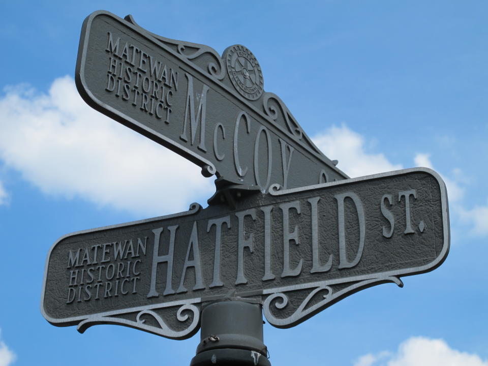 A Saturday, June 9, 2012 photo shows a street sign in Matewan, W.Va., that bears the names of the two families that once waged the country's most famous feud in this Appalachian region. The street corner is near where members of the two families competed in a tug of war during a recent festival. (AP Photo/Bruce Schreiner)