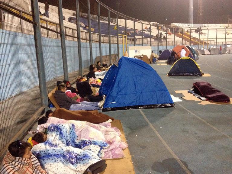 Locals take refuge at the city stadium following a tsunami alert after a powerful 8.2-magnitude earthquake hit off Chile's Pacific coast, on April 2, 2014 in Iquique