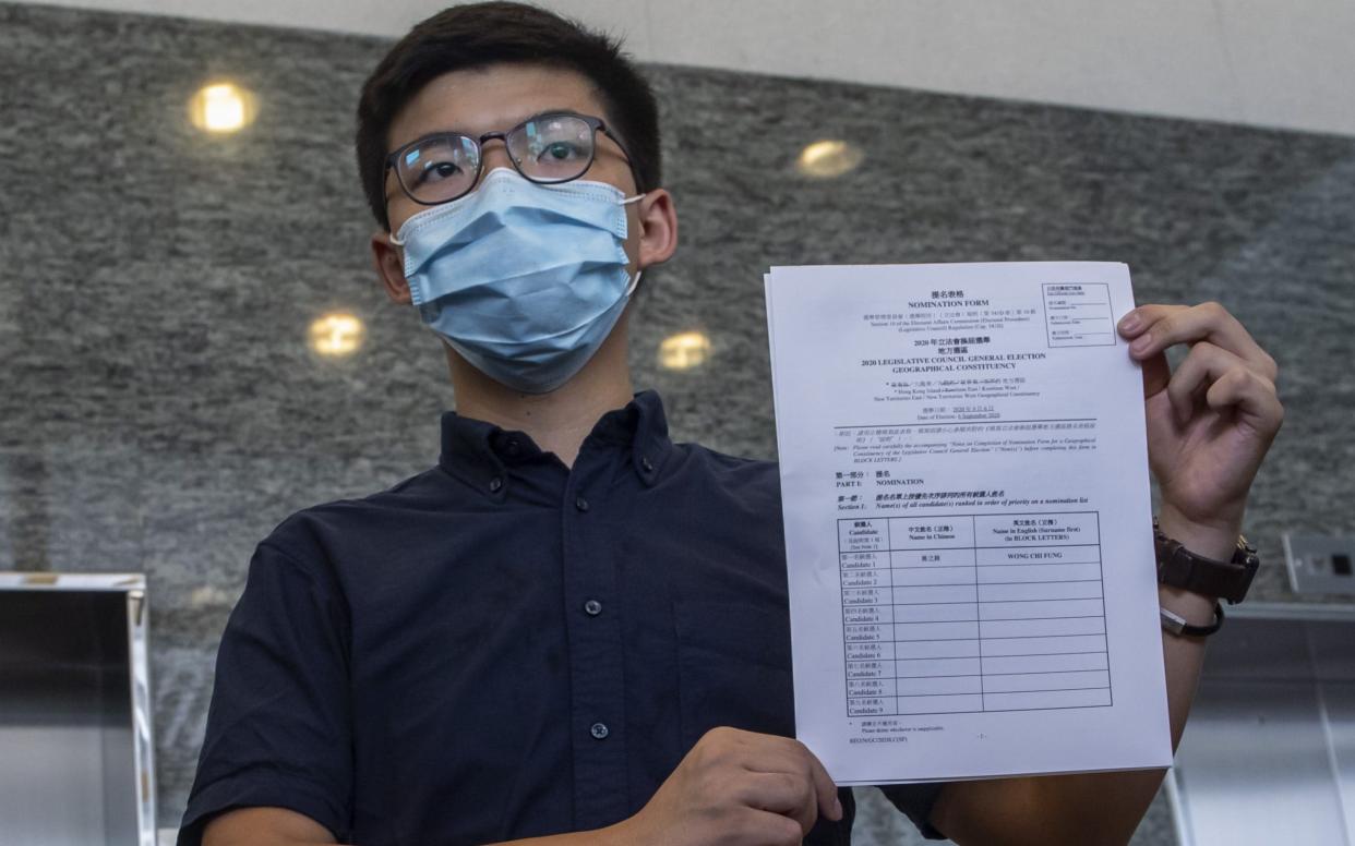 Joshua Wong, submitting his papers for election to the legislative council in Hong Kong, has now been barred from standing  - Paul Yeung/Bloomberg