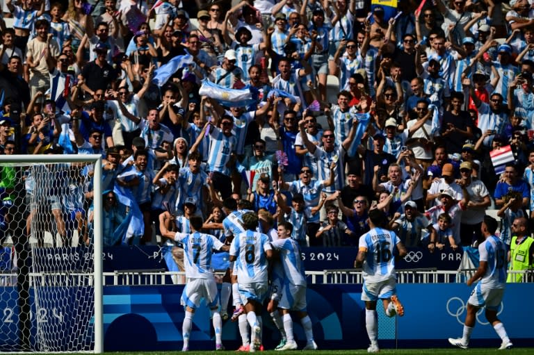 El mediocampista argentino Thiago Almada celebra con sus compañeros el primer tanto de la victoria contra Ucrania, en el cierre del Grupo B del torneo olímpico masculino de París 2024, en el estadio de Lyon el 30 de julio de 2024. (Olivier CHASSIGNOLE)