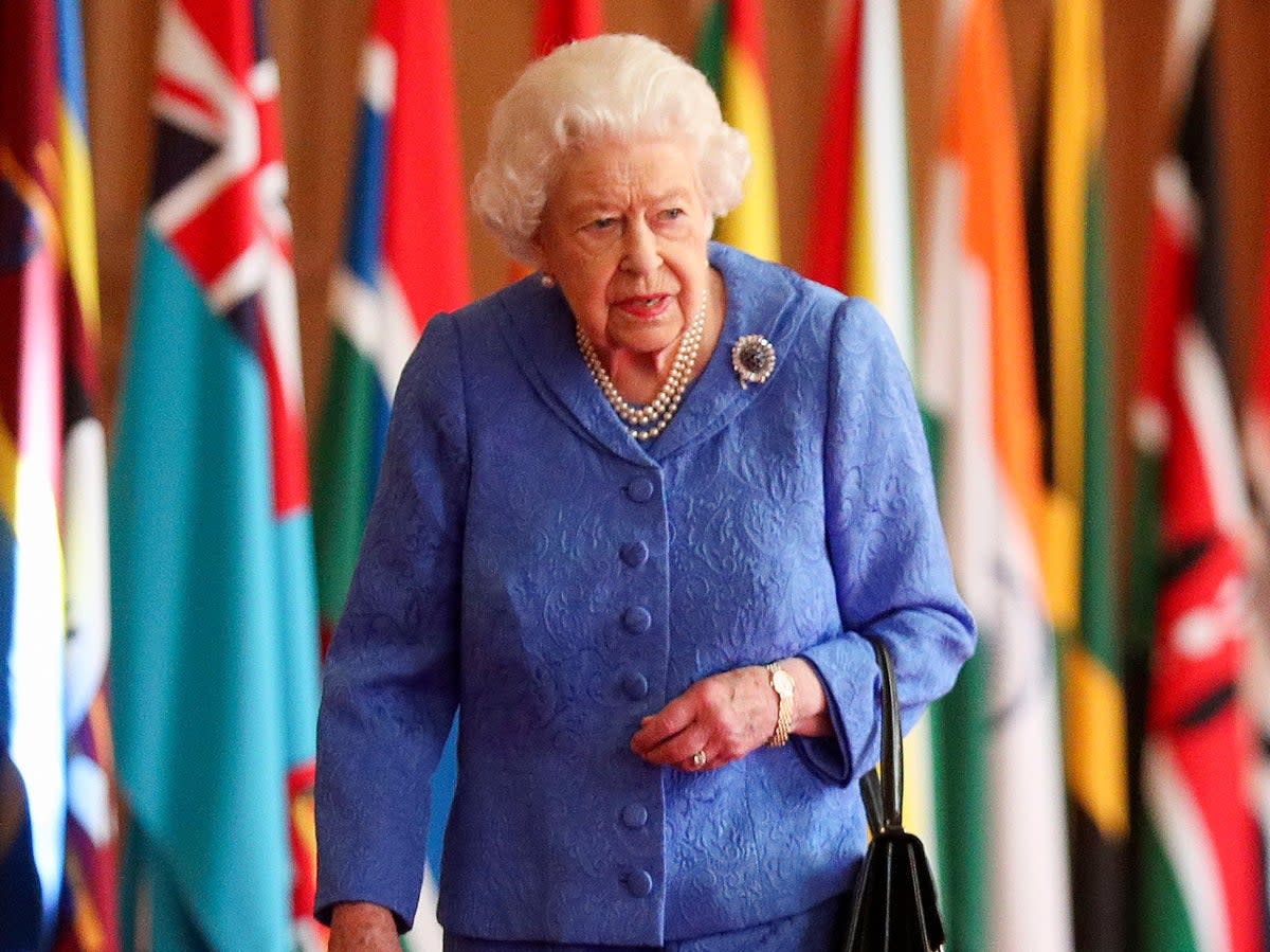 Queen Elizabeth II walks past Commonwealth flags in St George’s Hall at Windsor Castle on 6 March, 2021 (Getty)