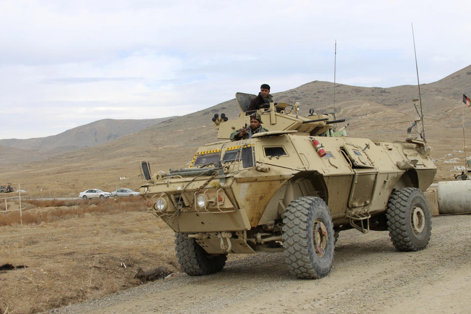 Afghan national army soldiers arrive at the site of a suicide bombing in Ghazni province west of Kabul, Afghanistan, Sunday, Nov. 29, 2020. Over 30 people were killed on Sunday in two separate suicide bombings in Afghanistan that targeted a military base and a provincial chief, officials said. (AP Photo/Rahmatullah Nikzad)