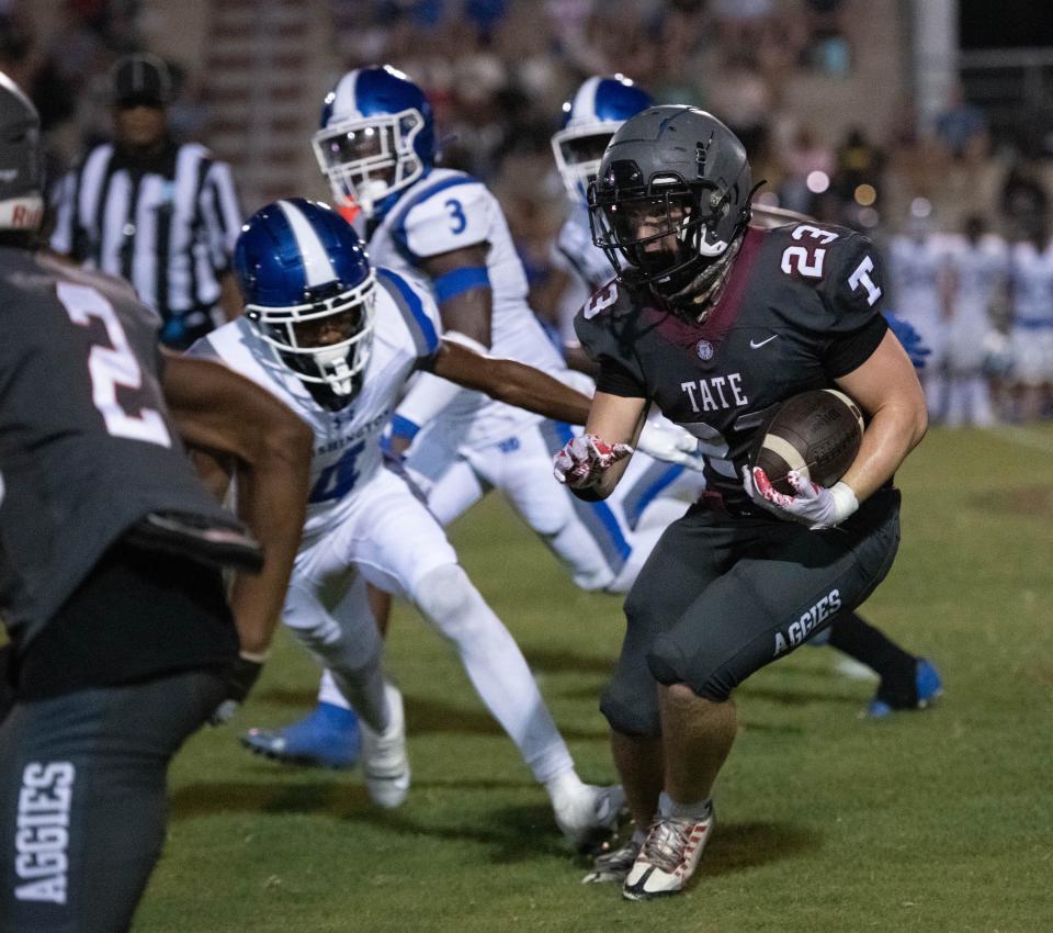 Carson Secchiari (23) carries the ball during the Washington vs Tate Kickoff Classic football at Tate High School in Cantonment on Thursday, Aug. 17, 2023.