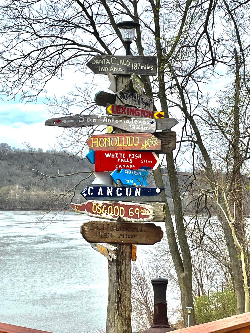 A riverbank sign indicates distance to some of the hometowns of visitors to the museum and regatta.