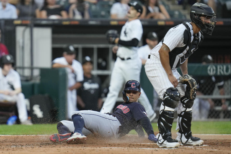 Cleveland Guardians' Andres Gimenez slides past Chicago White Sox catcher Seby Zavala to score during the third inning of a baseball game Thursday, July 27, 2023, in Chicago. (AP Photo/Erin Hooley)