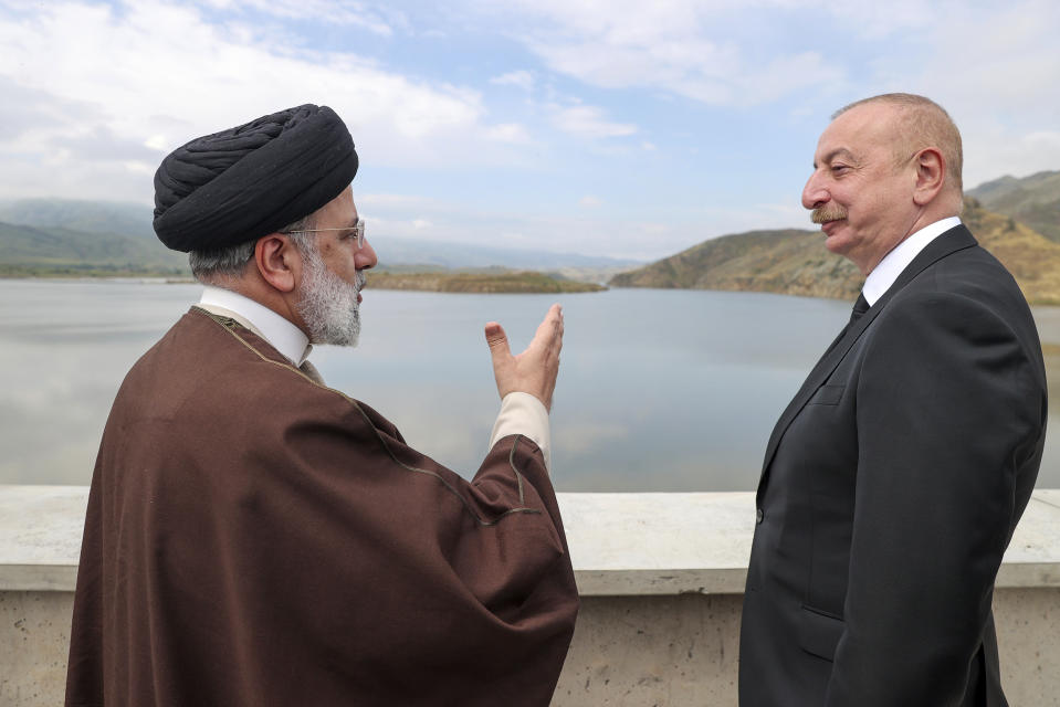 In this photo released by the Iranian Presidency Office, President Ebrahim Raisi, left, speaks with his Azeri counterpart Ilham Aliyev on the inauguration of dam of Qiz Qalasi, or Castel of Girl in Azeri, at the border of Iran and Azerbaijan, Sunday May 19, 2024. A helicopter carrying Iranian President Ebrahim Raisi suffered a "hard landing" on Sunday, Iranian state media reported, without immediately elaborating. (Iranian Presidency Office via AP)