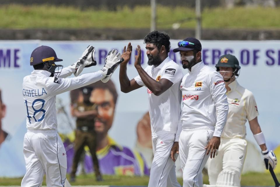 FILE - Sri Lanka's Prabath Jayasuriya, second left, celebrates taking the wicket of Australia's Mitchell Starc with teammates during the second day of the second test cricket match between Australia and Sri Lanka in Galle, Sri Lanka, Saturday, July 9, 2022. Sri Lanka was in contention for the World Test Championship final until March. That prospect has whetted its appetite to get there in the new cycle. The campaign starts on Sunday, when Sri Lanka plays Pakistan in Galle in the first of two tests. (AP Photo/Eranga Jayawardena, File)