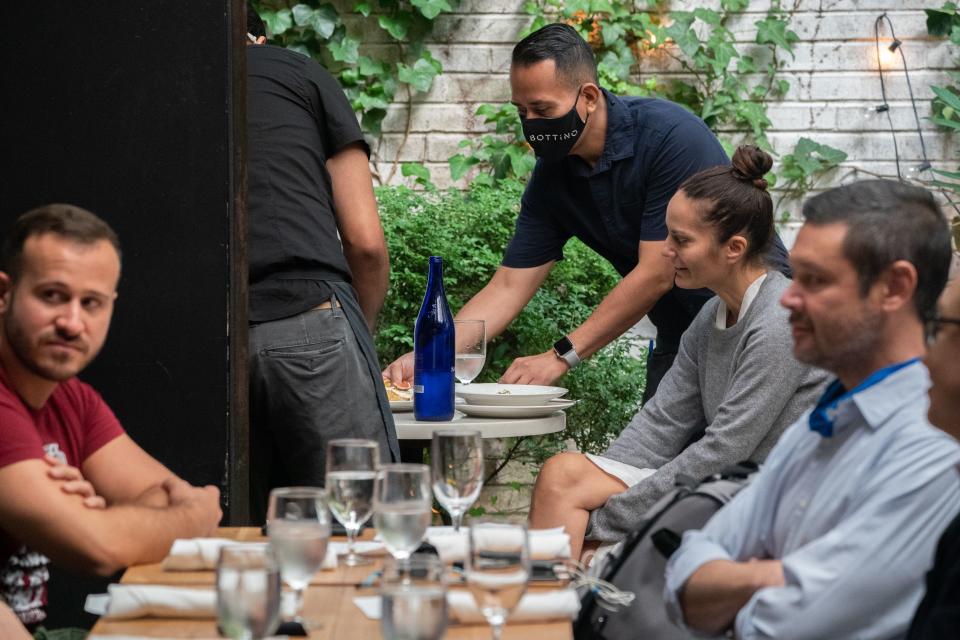 People have lunch at Bottino Restaurant in Chelsea as New York City restaurants open for limited capacity indoor dining on October 1, 2020 in New York. (Photo by Bryan R. Smith / AFP) (Photo by BRYAN R. SMITH/AFP via Getty Images)