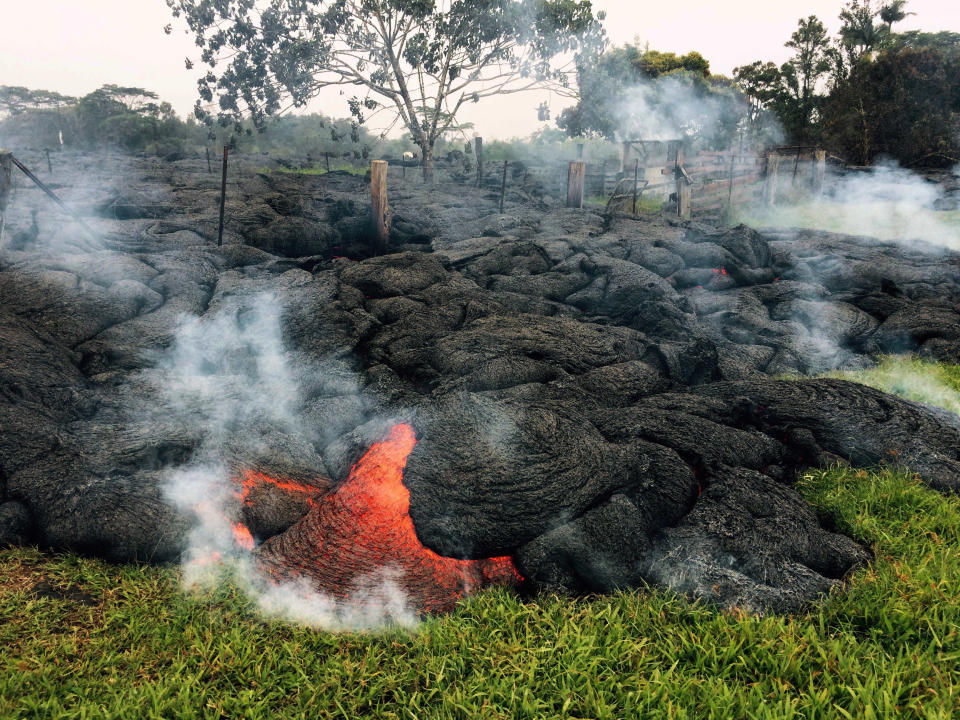 This Oct. 26, 2014 photo provided by the U.S. Geological Survey shows the lava flow front of from an eruption that began the June 27, as the front remains active and continues to advance towards the northeast threatening the town of Pahoa on the Big Island of Hawaii. Dozens of residents in this rural area of Hawaii were placed on alert as flowing lava continued to advance. Authorities on Sunday, Oct. 26, 2014 said lava had advanced about 250 yards since Saturday morning and was moving at the rate of about 10 to 15 yards an hour, consistent with its advancement in recent days. The flow front passed through a predominantly Buddhist cemetery, covering grave sites in the mostly rural region of Puna, and was roughly a half-mile from Pahoa Village Road, the main street of Pahoa. (AP Photo/U.S. Geological Survey)