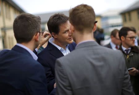 Britain's Liberal Democrat party leader and Deputy Prime Minister Nick Clegg has an ear piece removed as he speaks with members of the media after a visit to Millie's Trust in Manchester, northern England, April 2, 2015. REUTERS/Darren Staples