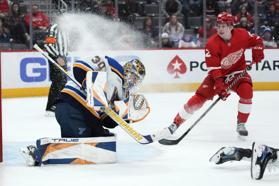 St. Louis Blues goaltender Joel Hofer (30) stops a shot as Detroit Red Wings right wing Matt Luff (22) looks for a rebound in the second period of an NHL hockey game Thursday, March 23, 2023, in Detroit. (AP Photo/Paul Sancya)