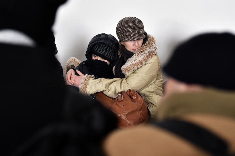 A Kosovo Albanian woman hugs her child at a police station near the northern Serbian city of Subotica close to the Hungarian border on February 9, 2015