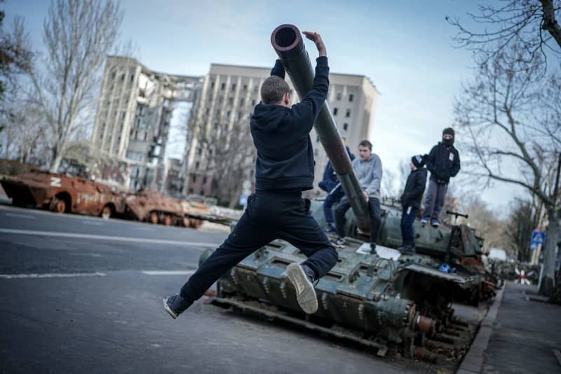 Children play on a destroyed Russian tank in front of the former headquarters of the regional administration of Mykolaiv oblast, after the visit of the German Foreign Minister. On March 29, 2022, the building was hit by Russian missiles and almost completely destroyed. Mykolaiv is an important port city near Odessa. Kay Nietfeld/dpa