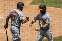 Baltimore Orioles' Anthony Santander, left, gives teammate Pat Valaika, right, an elbow-bump after Valaika scored a run on Hanser Alberto's two-run double during the fifth inning of a baseball game against the Washington Nationals in Washington, Sunday, Aug. 9, 2020. (AP Photo/Manuel Balce Ceneta)