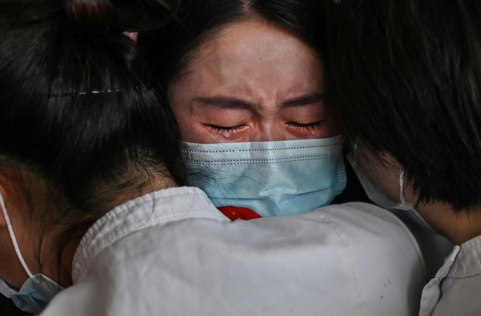 Medical staff Jilin Province hug nurses from Wuhan after working together during coronavirus outbreak during a ceremony.