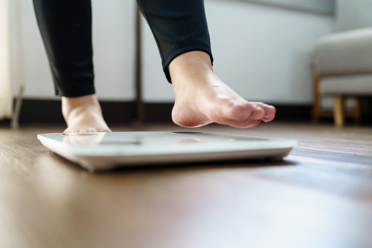 Obese Woman with fat upset bored of dieting Weight loss fail  Fat diet and scale sad asian woman on weight scale at home weight control