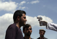 FILE-In this May 3, 2020, file, photo, a health worker checks the temperature of car passengers in an effort to help stop the spread of the coronavirus, as they enter the city in the Paghman district of Kabul, Afghanistan. A prominent international aid organization warned Tuesday, June 2, 2020 that Afghanistan is on the brink of a humanitarian disaster because the government is unable to test at least 80% of possible coronavirus cases.(AP Photo/Rahmat Gul, File)