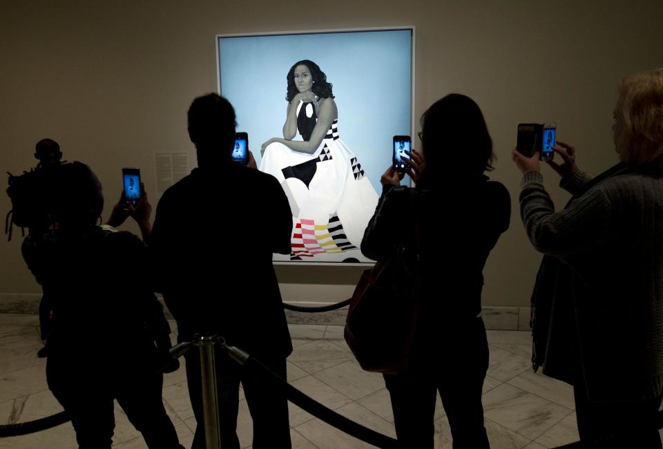 Visitors take pictures of the official portrait of the former first lady Michelle Obama in the first day open exhibit at the Smithsonian's National Portrait Gallery, Tuesday, Feb. 13, 2018, in Washington. Barack Obama's portrait was painted by artist Kehinde Wiley, and Michelle Obama's portrait was painted by artist Amy Sherald. (AP Photo/Jose Luis Magana) ORG XMIT: DCJL104