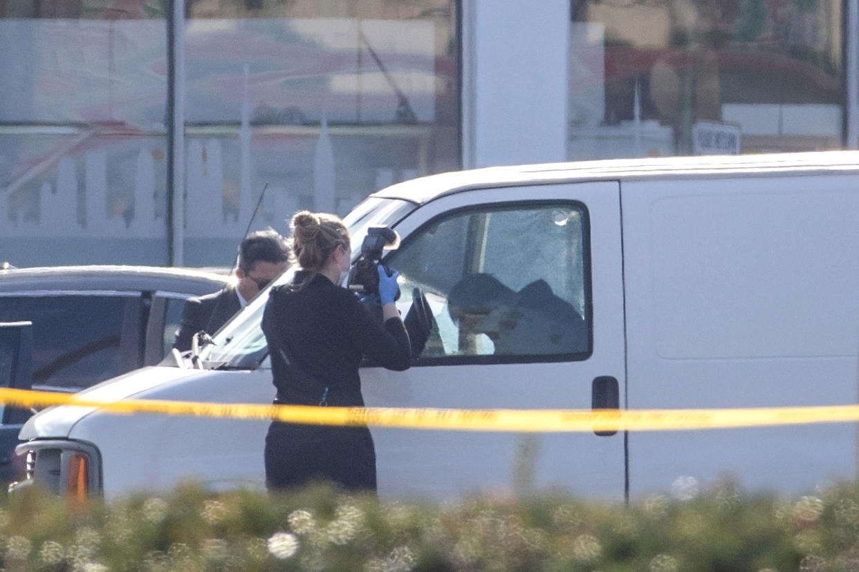 A coroner official takes photos of the Monterey Park gunman, who died of an apparent self-inflicted gunshot wound, in his van in Torrance, Calif., on Sunday. (Allen J. Schaben/Los Angeles Times via Getty Images)