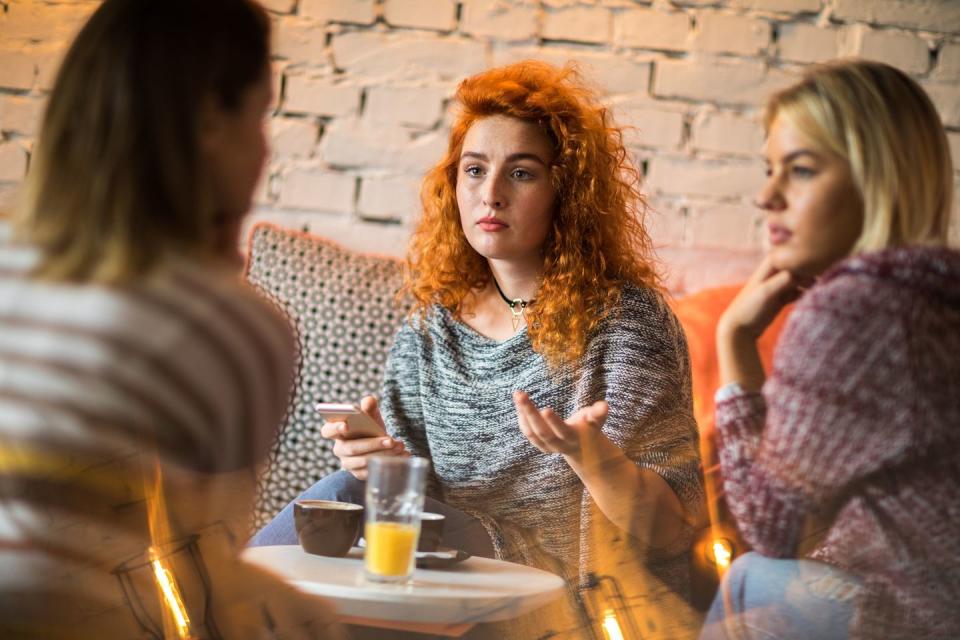 friends having serious conversation in cafe