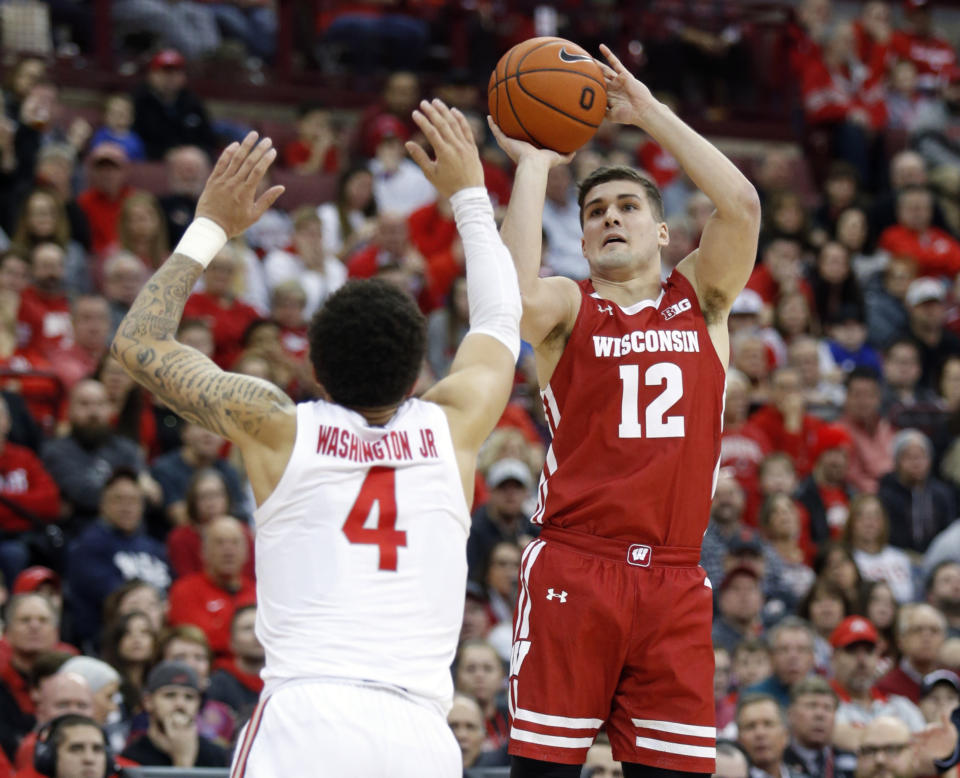 Wisconsin guard Trevor Anderson, right, goes up to shoot in front of Ohio State guard Duane Washington during the first half of an NCAA college basketball game in Columbus, Ohio, Friday, Jan. 3, 2020. (AP Photo/Paul Vernon)