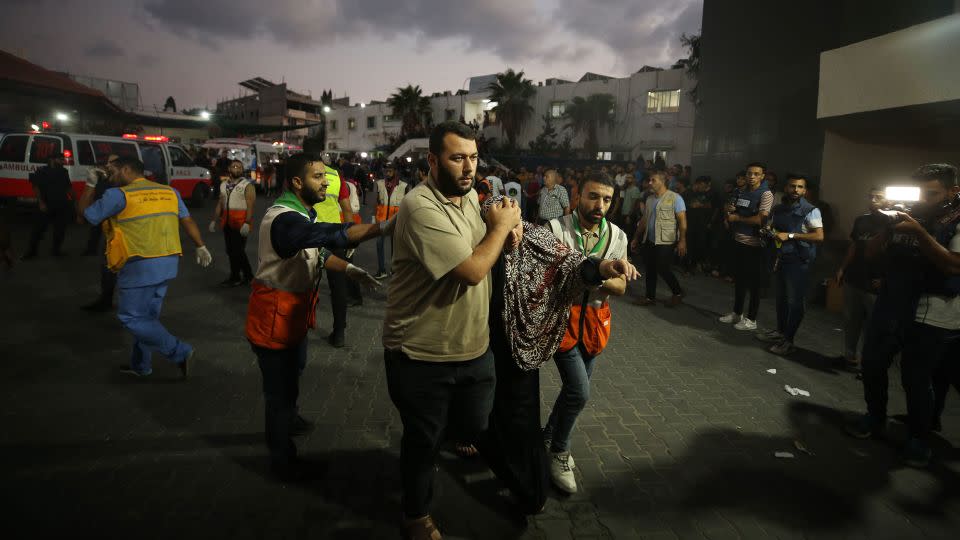 Medical staff carry injured people to Al-Shifa Hospital, in Gaza City, on October 11. Relief workers warned the health care system in Gaza is crumbling under an Israeli blockade. - Mustafa Hassona/Anadolu/Getty Images