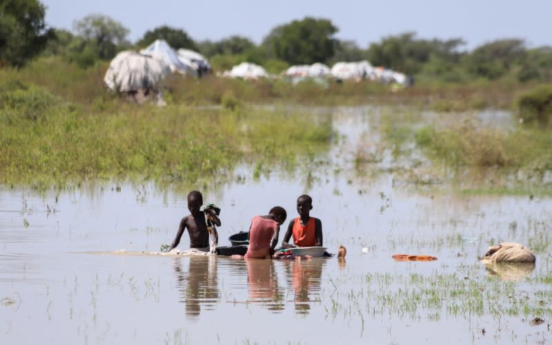 FILE PHOTO: Children displaced by floods clean their laundry within the flood waters in Gumuruk, Boma state, in the Greater Upper Nile region