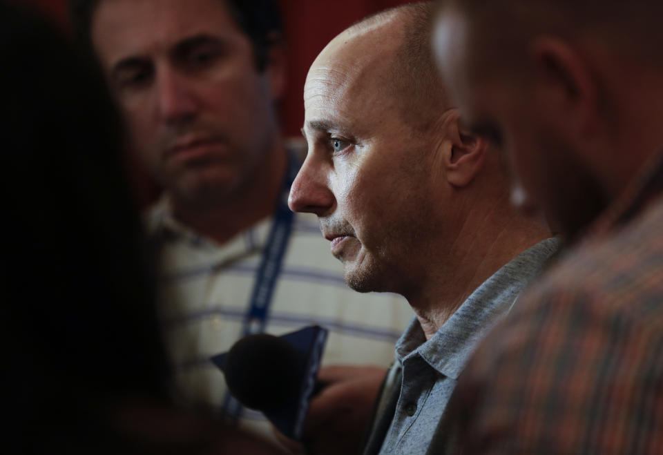 New York Yankees general manager Brian Cashman, center, speaks to reporters during the baseball GM meetings Wednesday, Nov. 7, 2018, in Carlsbad, Calif. (AP Photo/Gregory Bull)