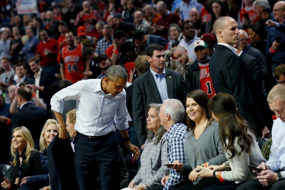 U.S. President Barack Obama takes off his coat as he attends an NBA opening night game between the Cleveland Cavaliers and the Chicago Bulls in Chicago October 27, 2015. Earlier Tuesday Obama delivered remarks at an International Association of Chiefs of Police (IACP) conference and attended Democratic Party events in Chicago. REUTERS/Jonathan Ernst