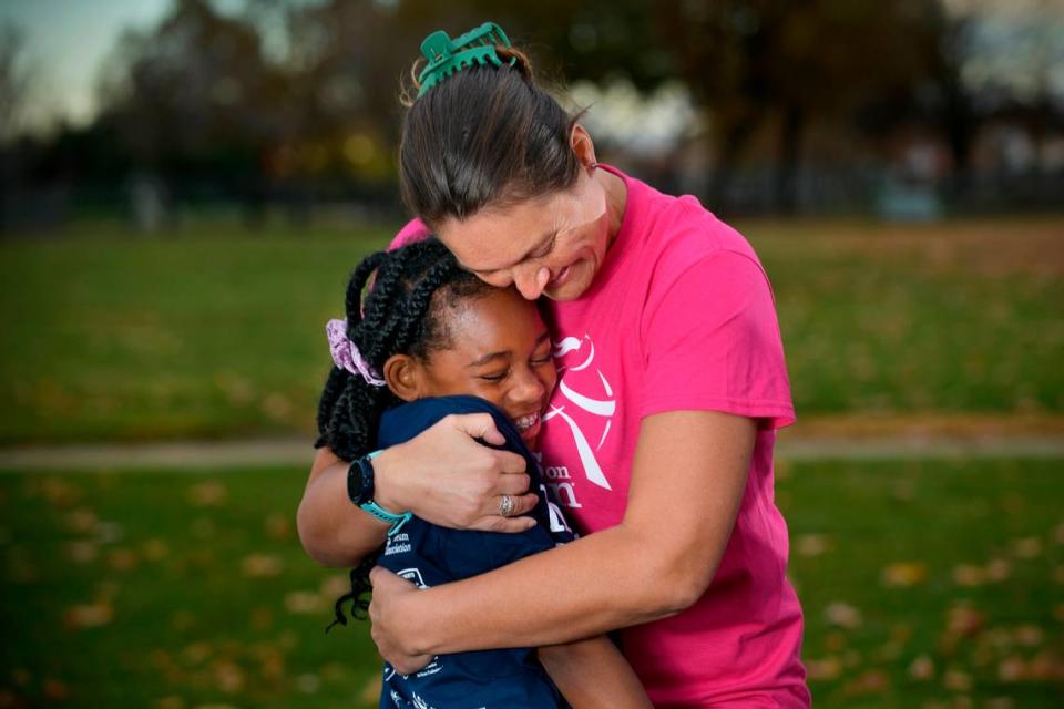 Girls on the Run of Greater Sacramento volunteer coach Candace Beam hugs Charlea Hill, 11, at Joseph Sims Elementary School in Elk Grove on Thursday, Dec. 1, 2022. Hill is one of several young ladies mentored in their program that culminates in a 5K run.