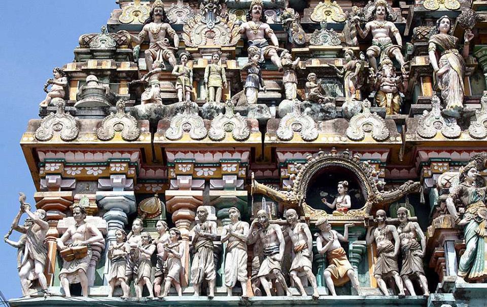 A temple relief depicting Appar bearing Sambandar's palanquin at Thirukadaiyur Temple, Tamil Nadu. This is one of the Ashta Veeratta sthalams -- the eight places where Lord Shiva materialized in his furious aspect -- and here Lord Shiva saved Markandeya from Yama, the god of death. This temple belongs to Dharmapuram Aadinam (Mutt). This temple deities are sung of by the Tamil trinity, i.e, Appar, Sundarar and Thirugnana Sambandar. The presiding deity is Amruthakadeswarar. His consort is Abhirami. Abhirami Andhathi was written here by Abhirami Bhattar. The temple is in line with the grand temple architecture of the Cholas and occupies a vast area of 11 acres with five Prakarams, imposing temple towers and large and spacious Mandapams. In the figural gopuram, the story of close association of Appar (bearing palanquin) and Thirugnana Sambandar (sitting in the palanquin) is well depicted. Thirukadaiyur is about 15 km from Karaikal.