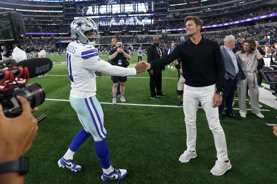 Dallas Cowboys linebacker Micah Parsons, left, greets Tom Brady, right, on the field during warmups before the team's preseason NFL football game against the Las Vegas Raiders in Arlington, Texas, Saturday, Aug. 26, 2023. (AP Photo/Sam Hodde)