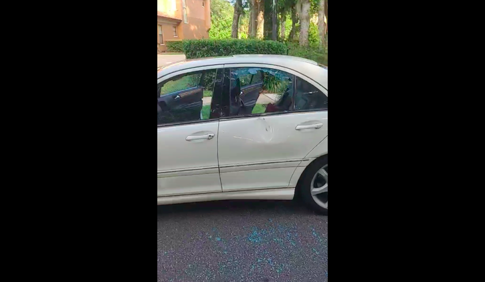 The father of the 16-year-old, CJ Jones, surveys the damage done to the white Mercedes after a rock was allegedly hurled at his son while he was in the driver’s seat (Facebook/CJ Jones)