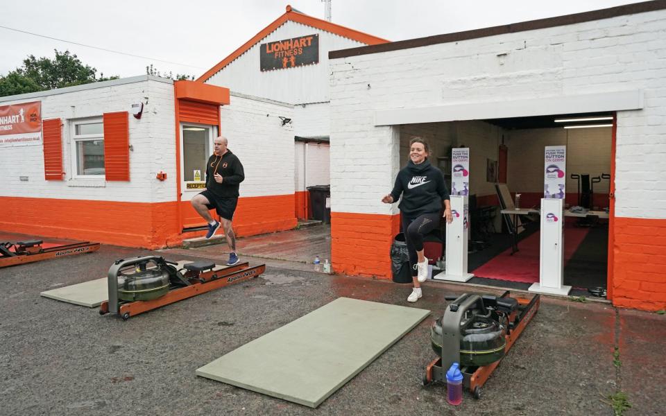 People take part in a small exercise class at the Lionheart Fitness gym, which has moved some equipment into its car park, with indoor gyms still not permitted to open - PA