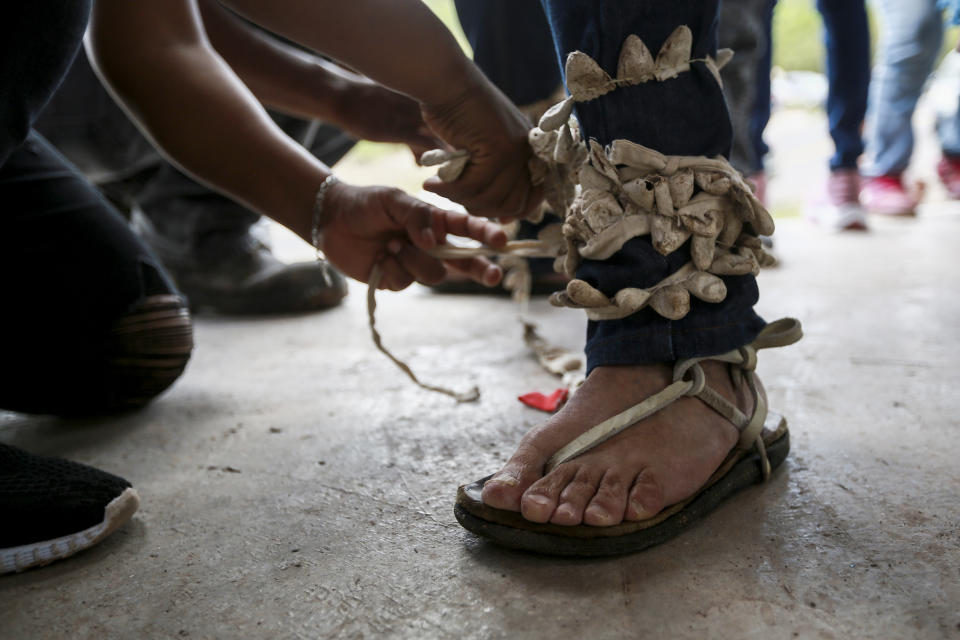 A Tarahumara dancer prepares to perform the traditional ritual "Pascol," before receiving the funeral procession of Jesuit priests Javier Campos Morales and Joaquin Cesar Mora Salazar in Cerocahui, Chihuahua state, Mexico, Sunday, June 26, 2022. The two elderly priests and a tour guide murdered in Mexico's Sierra Tarahumara this week are the latest in a long line of activists, reporters, travelers and local residents who have been threatened or killed by criminal gangs that dominate the region. (AP Photo/Christian Chavez)