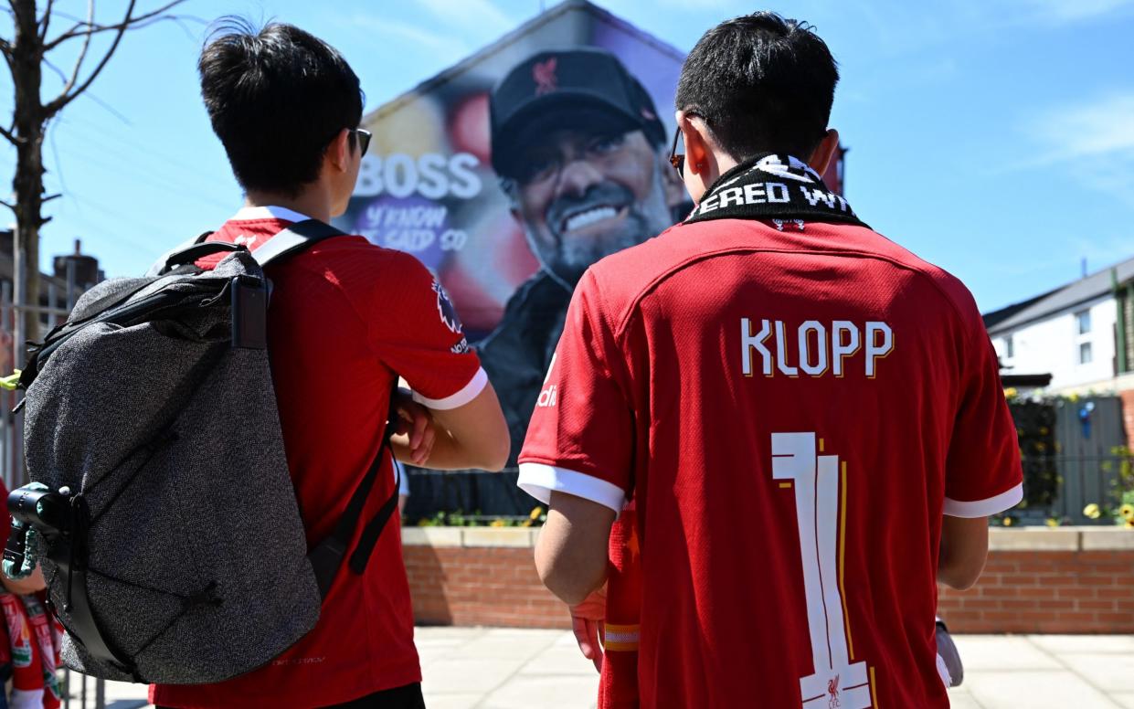 Fans stop to view a mural of Liverpool's German manager Jurgen Klopp by artist Hugh Whitaker from MurWalls near to the ground as they arrive for the English Premier League football match between Liverpool and Wolverhampton Wanderers