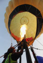 WOOTTON, UNITED KINGDOM - APRIL 07: A hot air balloonist makes preparations for departure from Lydden Hill race circuit near Canterbury to take part in a mass crossing of the Channel on April 7, 2011 in Wootton, England. 51 balloonists of various nationalities from across Europe took off from Kent making for Calais, France at about 7am. It is the first time a Guinness World Record bid has been made for "the largest group of hot air balloons to make the Channel crossing". (Photo by Oli Scarff/Getty Images)