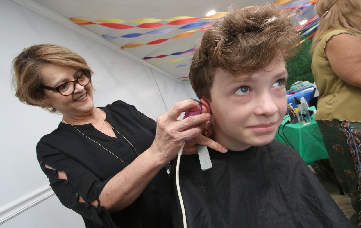 Twelve-year-old Sean Stafford gets a free haircut from Maria Hutton during the annual Back to School Bash Saturday morning, July 22, 2023, at the Cherryville Church of God.