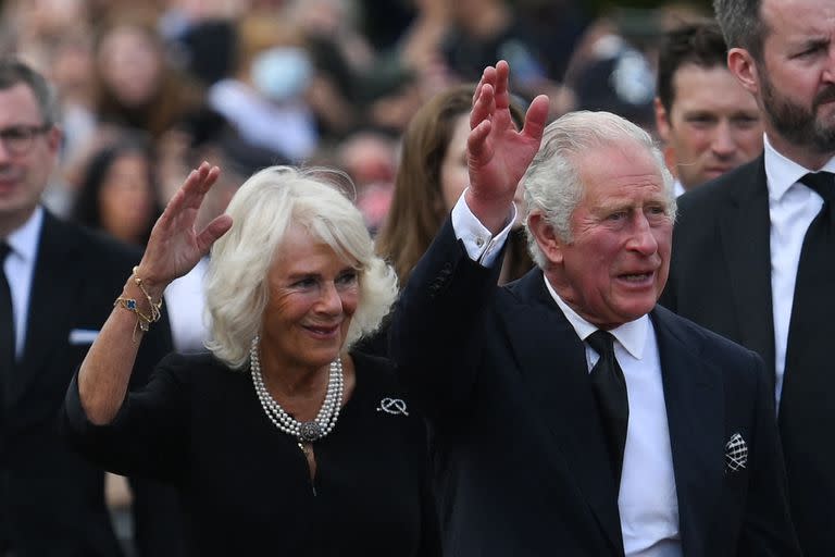 El rey Carlos III (derecha) de Gran Bretaña y la reina consorte Camilla de Gran Bretaña saludan a la multitud a su llegada al Palacio de Buckingham en Londres, el 9 de septiembre de 2022