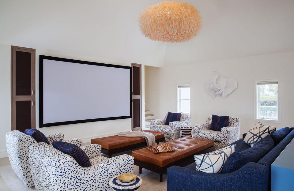 <p>Set up a projector for movie nights and video games. Paired with elevated furniture, it can double as a family or living room. Heather Hilliard Design chose a blue and white color scheme with splashes of earth tones to warm it up. </p>