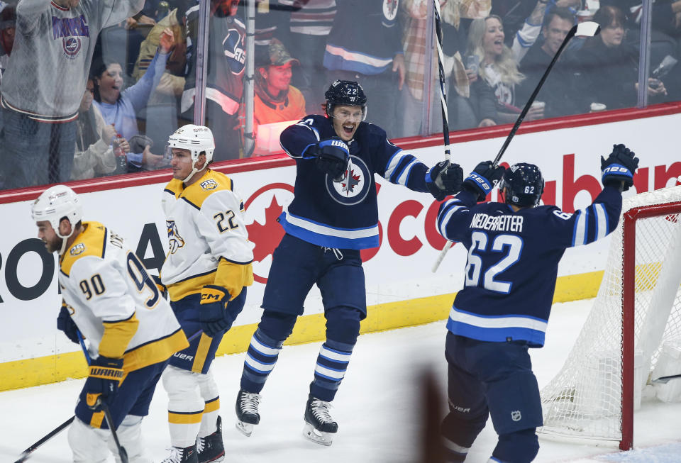 Winnipeg Jets' Mason Appleton, center, and Nino Niederreiter (62) celebrate Appleton's goal against the Nashville Predators during the first period of an NHL match in Winnipeg, Manitoba, on Thursday, Nov. 9, 2023. (John Woods/The Canadian Press via AP)