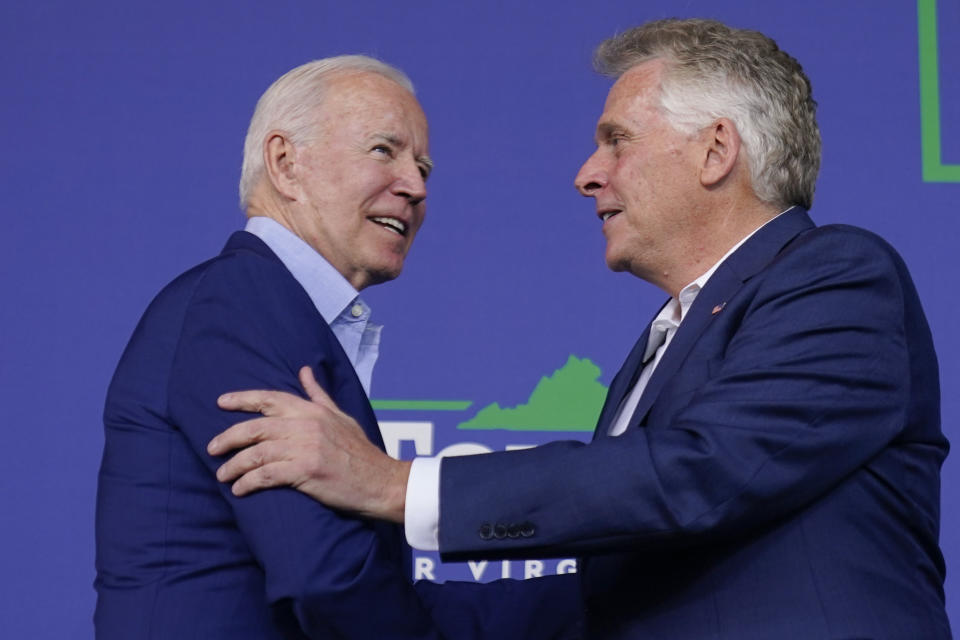 FILE - In this July 23, 2021 file photo, President Joe Biden greets Virginia democratic gubernatorial candidate Terry McAuliffe as he arrives to speak at a campaign event for McAuliffe at Lubber Run Park, in Arlington, Va. As workers return to the office, friends reunite and more church services shift from Zoom to in person, this exact question is befuddling growing numbers of people: to shake or not to shake. (AP Photo/Andrew Harnik, File)