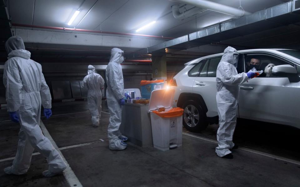 People are tested for the coronavirus by healthcare workers at a drive-through testing site during a nationwide lockdown to curb the spread of the virus - AP Photo/Oded Balilty