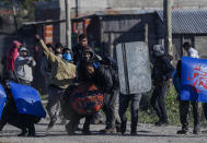 La gente enfrenta a la policía que lleva a cabo el desalojo en su campamento de ocupantes ilegales en Guernica, provincia de Buenos Aires, Argentina, el jueves 29 de octubre de 2020. (AP Foto/Natacha Pisarenko)