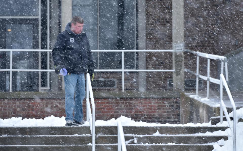 A flurry of flying snow and salt as Rick Burgess keeps the entryway to Barnstable District Court clear getting ready for a delayed court opening because of the weather.